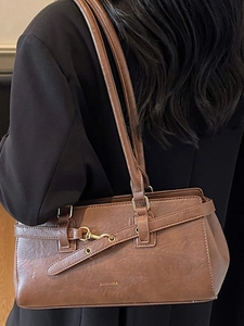 Brown vintage faux leather large capacity shoulder bag shown on a model in a black suit
