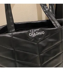 Detail of black quilted tote bag with white CHAOHUO embroidery and soft leather texture