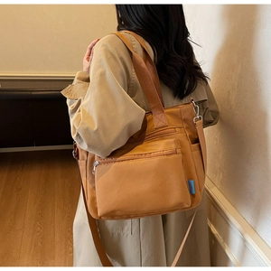 Detail view of khaki brown large capacity tote bag featuring multi-pocket functional design