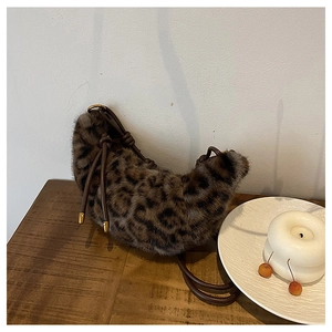 Détail de la texture peluche léopard et de la bandoulière en cuir brun sur un sac hobo
