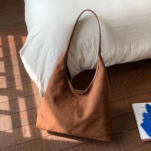 Close-up detail of large caramel suede Hobo tote bag with smooth leather strap accents