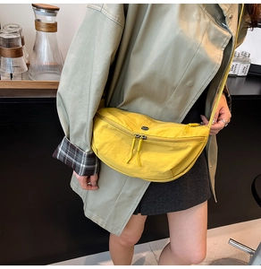 Detail van een felgele nylon halvemaanvormige crossbodytas met dubbele ritssluiting