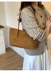 Detail showing high-quality brown suede leather texture and thin shoulder straps of tote bag