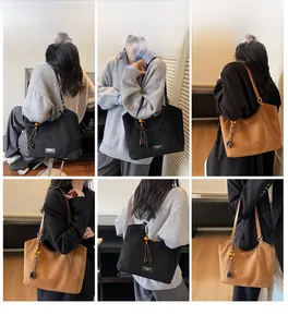 Vues détaillées de grands sacs cabas en noir et marron avec texture suédée et pompons décor