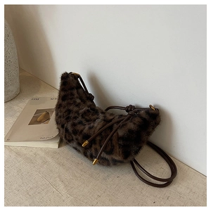 Détail du sac croissant en peluche léopard avec bandoulière en corde et décor doré