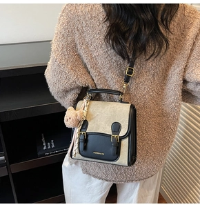 Détail du sac bandoulière rétro avec tissu texturé et charmant pendentif ours