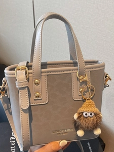 Sac seau rétro en cuir gris avec poignées et charmant accessoire en peluche marron