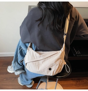 Λεπτομέρεια μπεζ νάιλον τσάντας χιαστί με ανάγλυφο ύφασμα και ρυθμιζόμενο ιμάντα ώμου