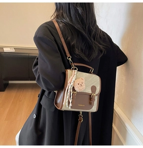 Détail d'un mini-sac à dos vintage avec breloque ours en peluche et décoration de ruban
