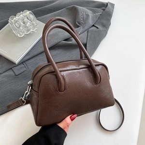 Close-up of retro brown Boston bag showing textured leather finish and silver hardware
