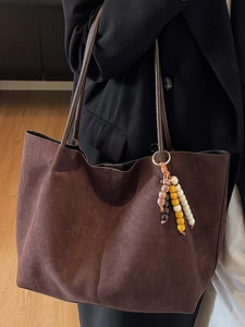 Minimalist large brown suede tote bag with decorative colorful beads on a model