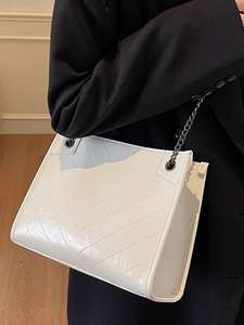 Borsa tote minimalista in vernice beige con trapuntatura a V e tracolla a catena