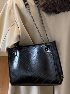 Borsa tote nera trapuntata minimalista con tracolla a catena metallica da donna