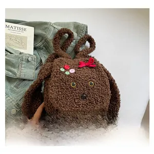 Détail d'un sac à dos en peluche marron avec oreilles de lapin et boutons colorés