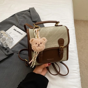 Détail du sac à dos vintage en toile avec cuir synthétique et charm d'ours