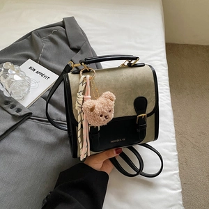 Détail du sac à dos rétro en toile et cuir avec pendentif ours en peluche rose mignon