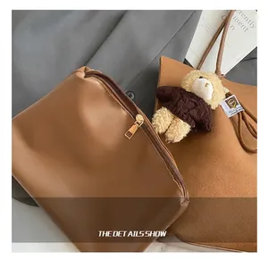 Nahaufnahme der braunen Shopper-Tasche aus Wildlederimitat mit edlen goldenen Reißverschlüssen