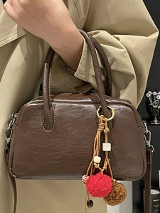 Vintage dark brown Boston handbag with textured leather and decorative ethnic tassel