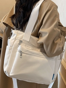 Minimalist white nylon tote bag with multi-zipper pockets and silver hardware detailing