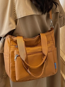 Minimalist caramel large tote bag with multi-zipper pockets and adjustable shoulder strap