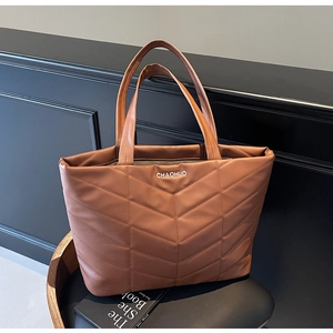 Close-up of brown quilted faux leather tote bag with V-shaped stitching detail