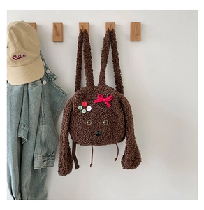 Détail d'un sac à dos chiot en peluche avec texture douce et nœud décoratif