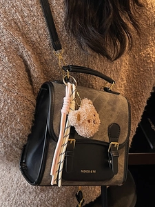 Sac à dos à la mode en toile grise et cuir noir avec breloque d'ours au style décontracté