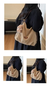 Detail view of beige minimalist tote bag with leather logo patch and plush bear charm