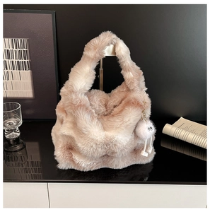 Close-up of soft light pink plush handbag with a cute fluffy eye-charm accessory