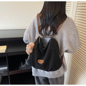 Black suede tote bag with brown leather straps and a cute plush bear charm detail