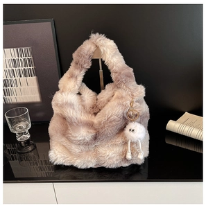 Close-up of plush gradient handbag with a cute fluffy monster doll charm detail