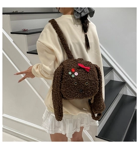 Détail d'un sac à dos chiot en peluche marron avec longues oreilles et nœud décoratif