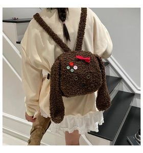 Vue détaillée du sac à dos peluche chien marron avec texture laine d'agneau et nœud rouge
