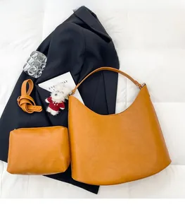 Detail view of mustard yellow faux leather tote set with grained texture and wide shoulder strap