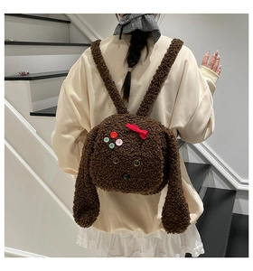 Vue détaillée du sac à dos peluche chiot avec trois boutons colorés et un nœud rouge