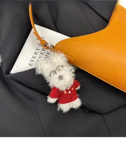 Plush white dog charm with glasses and red sweater on a chic orange handbag accessory