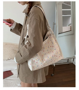 Detail view of floral tote bag with a beige pattern showing the strap and fabric texture