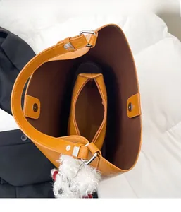 Close-up of brown tote bag with magnetic buckle and inner zipper pocket storage