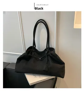 Detail view of large black velvet tote bag with long straps and decorative hanging tag