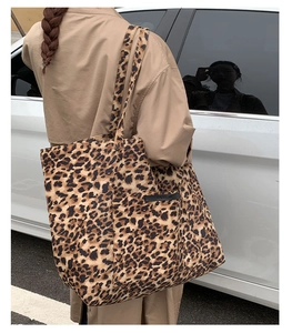Détail du grand sac cabas léopard avec poche extérieure porté par un mannequin