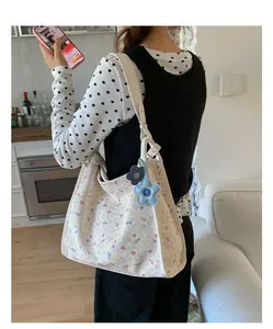 Detailed view of floral tote bag with blue flower charms on a stylish shoulder strap