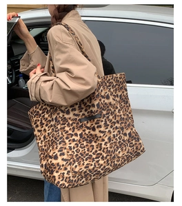 Détail du grand sac cabas à motif léopard porté à l'épaule avec un trench-coat décontracté