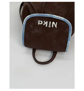Detail of soft brown suede backpack featuring vintage embroidery and checkered trim