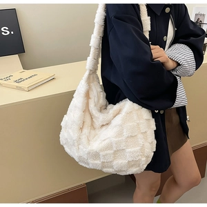 Detail of white plush tote bag showing checkerboard texture and secure zipper closure