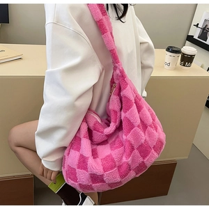 Side view of large pink checkerboard plush tote bag worn by a model in lifestyle setting