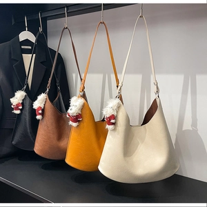 Detail view of large capacity hobo bags in four colors with plush dog charms for autumn