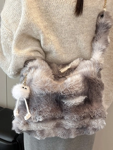 Gray and white faux fur shoulder bag with plush charm on a beige sweater outfit