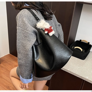 Détail du sac cabas en cuir plissé noir avec breloque ours mignon pour le quotidien