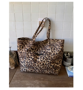Gros plan sur le sac fourre-tout en toile à motif léopard avec poche frontale élégante