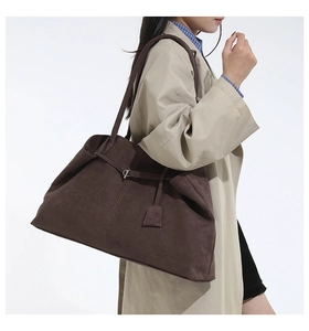 Détail d'un grand sac cabas marron en daim sur un mannequin portant un trench kaki